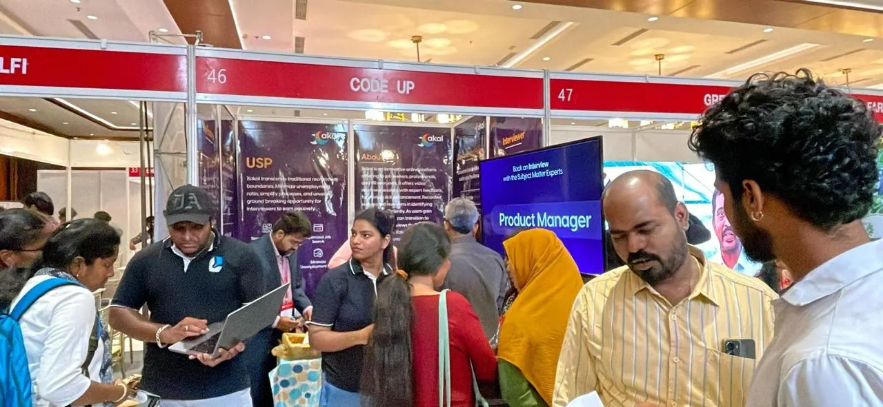 Visitors crowd the Xakal stall while a team member demos the app on a laptop