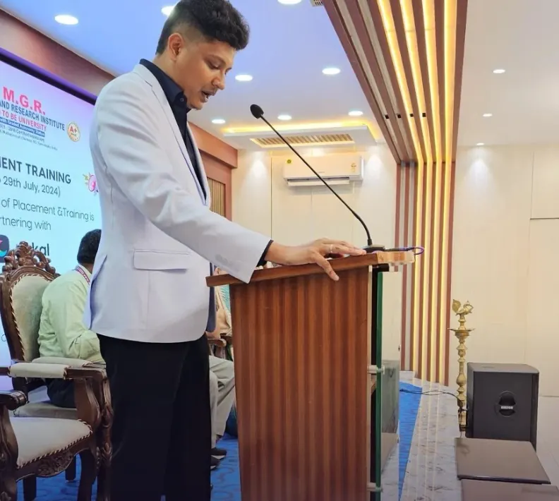 A Xakal speaker at the podium below the placement training banner