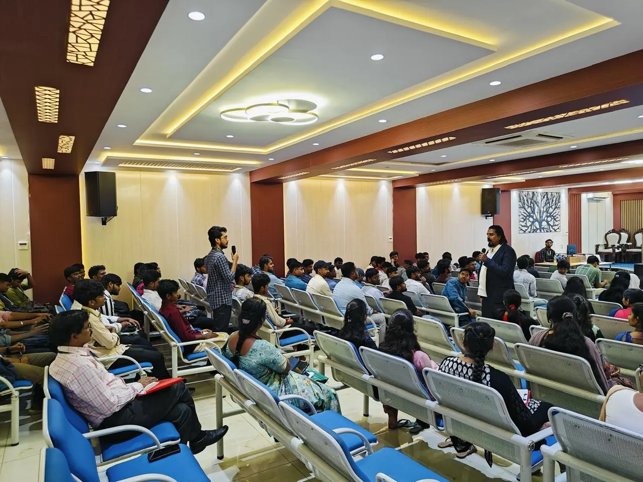 A student asks a question from the floor during a session