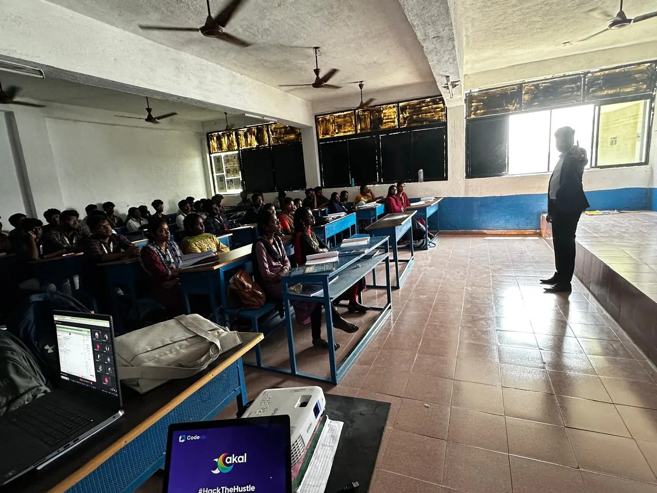 A Xakal speaker addresses a full classroom of students